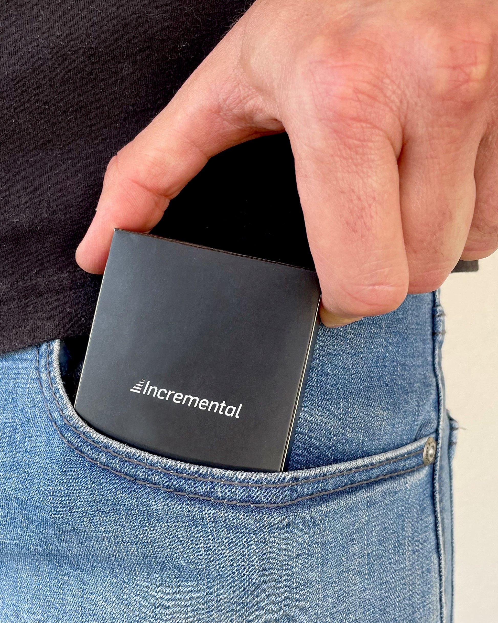 pack of incremental playing cards being inserted into the front pocket on a pair of jeans