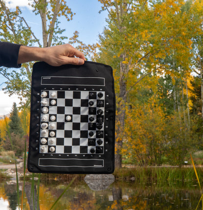 MagBoard being held vertically by a hand in front of fall leaves changing colors and a lake.