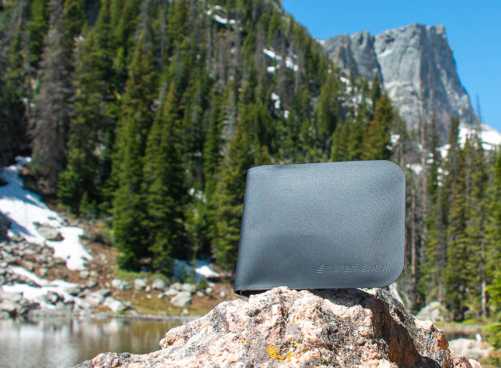 Incremental bifold wallet on a rock in front of a lake and mountain